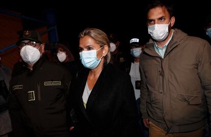 Jeanine Áñez, expresidenta interina, es escoltada por el ministro de Gobierno, Carlos Eduardo Del Castillo (a la derecha ), y el comandante de la policía boliviana, Jhonny Aguilera ( la izquierda), en el aeropuerto militar de El Alto (Bolivia), este sábado.