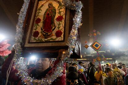 Un peregrino levanta un cuadro con la imagen de la Virgen de Guadalupe, a las afueras de la Basílica.