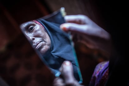 Amran Mahamood, que se gana la vida con la ablación de niñas, se ve reflejada en el pedazo de un espejo en Hargeisa. La tradición centenaria de la ablación femenina, también conocida como la mutilación genital femenina (MGF), está en declive en el norte de Somalia, a pesar de que sigue teniendo algunas de las tasas más altas de mujeres que se han sometido a la práctica en el mundo.