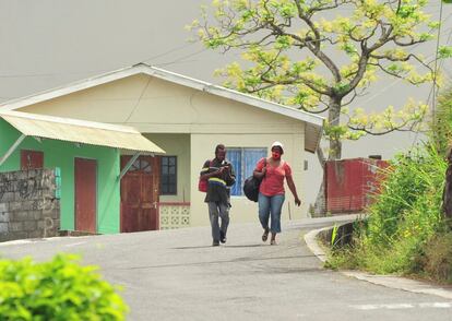 Personas evacuadas caminan por una carretera mientras se preparan para dejar el pueblo de Rose Hall, este viernes.