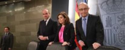 El ministro de Economía, Luis de Guindos, junto a la vicepresidenta, Soraya Sáenz de Santamaría, y el ministro de Hacienda, Cristóbal Montoro.