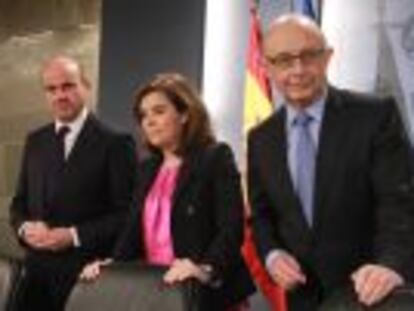 El ministro de Economía, Luis de Guindos, junto a la vicepresidenta, Soraya Sáenz de Santamaría, y el ministro de Hacienda, Cristóbal Montoro.