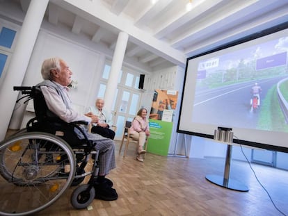 Un anciano juega en una residencia de mayores de Düsseldorf, en Alemania, a un simulador de conducción de una motocicleta, que maneja con los movimientos de sus manos. 