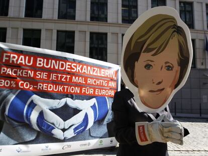 Un activista protesta con una m&aacute;scara de Angela Merkel en Bruselas.