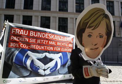 Un activista protesta con una máscara de Angela Merkel en Bruselas.
