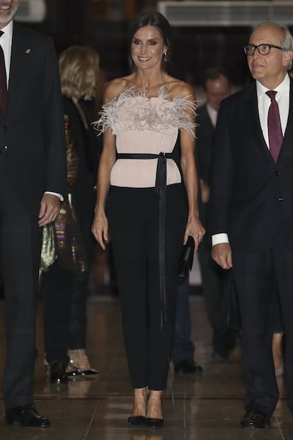 En el concierto de los premios Princesa de Asturias, la reina Letizia arriesgó con su primer estilismo con plumas. Se trata de un conjunto de la firma española The 2nd Skin Co —primera vez que esta marca entra en su armario— de top palabra de honor estilo corsé en color rosa polvo, con el toque de las plumas en la parte del pecho y un cinturón negro a la cintura, y un pantalón negro, que combinó con unos salones negros de Magrit. Pero el conjunto de la reina es único porque la firma lo adaptó especialmente para ella, siendo el original sin las plumas.