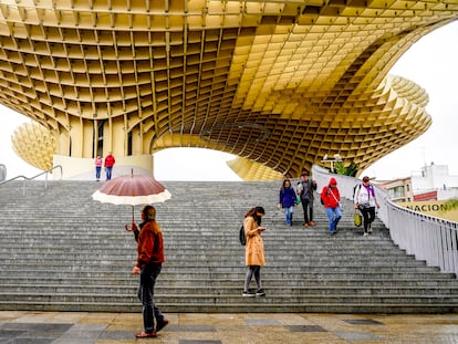 Varias personas pasean bajo la lluvia por las 'Setas de la Encarnación', el pasado 8 de marzo en Sevilla.