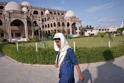 Un alumno pasa camino de clase delante del edificio principal de la madrasa Haqqanía, una famosa escuela coránica con 4.000 alumnos por la que han pasado importantes líderes talibanes, algunos de ellos en el actual gobierno de Kabul