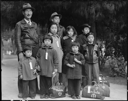 Miembros de la familia Mochida esperan el autobús de evacuación para después ser alojados en los centros de la Autoridad de Reubicación de Guerra.