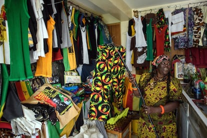 Una mujer rastafari originaria de Jamaica bromea con un amigo en su tienda de ropa. 