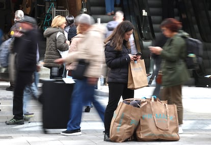 Varias personas realizan compras en comercios en la Gran Via, en el centro de Madrid.