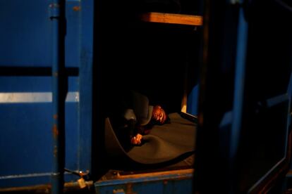 Un migrante tunecino duerme en un contenedor para protegerse del mal tiempo en el barco de rescate de migrantes de la ONG alemana Sea-Eye 'Alan Kurdi' en aguas internacionales frente a Malta en el mar Mediterráneo central.