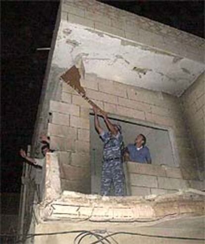 La policía palestina retira los restos del edificio de Al Fatah en Hebrón que pueden desprenderse.