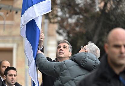 Eli Cohen (centro), ministro de Exteriores israelí, y Michael Brodsky, embajador del país en Ucrania, izan la bandera durante la apertura de la embajada en Kiev, este jueves.  