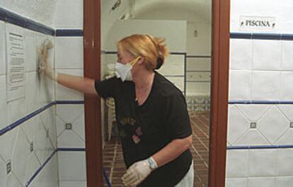 Una empleada limpia los baños del balneario de Cortes y  Graena.