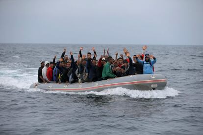 Migrantes saludan desde la embarcación en la que han cruzado el Estrecho hasta Tarifa, el 27 de julio.