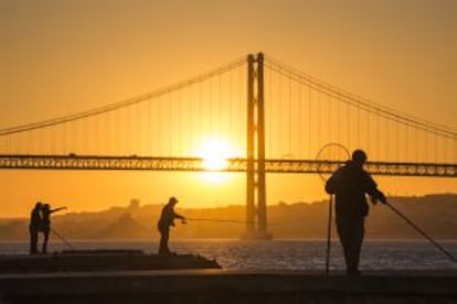 Pescadores en el muelle de Cacilhas al atardecer, frente a Lisboa.