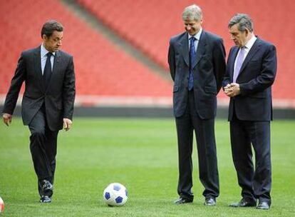 El presidente Sarkozy golpea un balón delante de Brown y del entrenador del Arsenal, el francés Arsène Wenger, ayer en Londres.