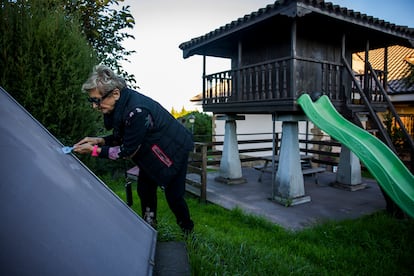 Ángela Menéndez trata de quitar los residuos de las placas solares de su casa, en el oeste de Gijón. 