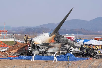 Bomberos y personal de rescate trabajan junto a los restos del avin accidentado en el aeropuerto de Muan (Corea del Sur), este domingo.