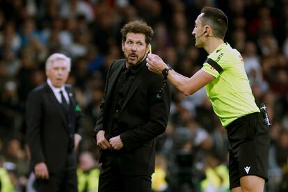 El árbitro Sánchez Martínez  conversa con Simeone, durante el Real Madrid-Atlético de Madrid (1-1) disputado este domingo en el Santiago Bernabéu.