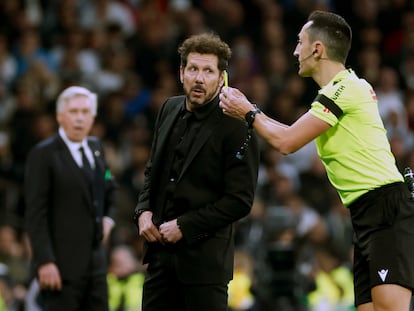 El árbitro Sánchez Martínez  conversa con Simeone, durante el Real Madrid-Atlético de Madrid (1-1) disputado este domingo en el Santiago Bernabéu.