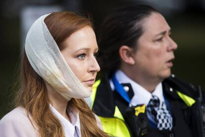 Uma agente da polícia escolta uma ferida nos arredores da estação de metrô Parsons Green.