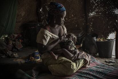Una madre alimenta a su hijo con desnutrición en un campo de refugiados.