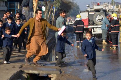 Un profesor y unos escolares cruzan una zona de enfrentamientos cerca del consulado de Pakistán en Jalalabad, Afganistán.