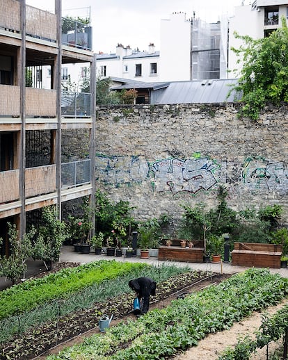 Un residente de la Ferme du Rail trabaja en la granja. La Ferme du Rail es la primera granja de policultivo e integración de París. La granja urbana, fundada en 2014, en el distrito 19 de París, ofrece alojamiento social y estudiantil in situ, y un restaurante accesible para la población local. 