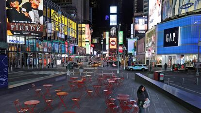 Una mujer camina por un Times Square casi vacío.