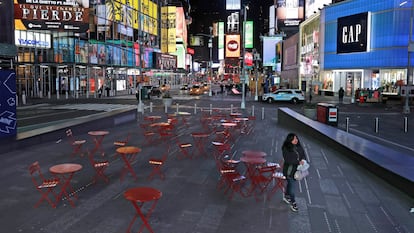 Una mujer camina por un Times Square casi vacío.