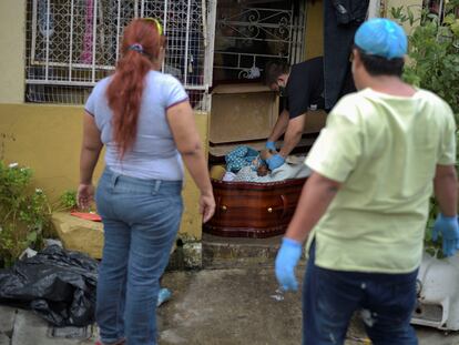  Una mujer observa un ataúd con el cadáver de su madre, fallecida por coronavirus. En el video, habitantes de Guayaquil muestran los cadáveres de sus familiares dentro de las casas.