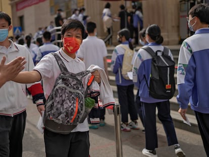 Los estudiantes son animados por voluntarios mientras entran en una escuela para realizar la prueba de acceso a la universidad en Pekín.
