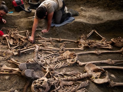 Dos arqueólogos intervienen en la fosa CE017 del Barranco de Viznar, en Granada.