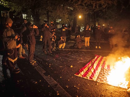 Manifestantes queman bandera estadounidense en Portland. En vídeo, protestas tras la noche electoral.