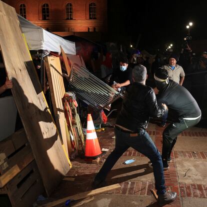 Contramanifestantes derriban una barricada en el campamento propalestino de la Universidad de Los Ángeles, en California, esta madrugada.