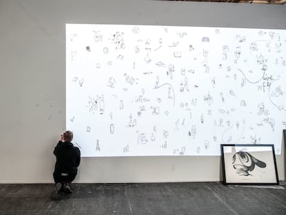 Foto: Edgar Plans dibuja en su espacio para EL PAÍS en Arco. /Vídeo: El artista explica 'My Daily News' desde su estudio, en Gijón.