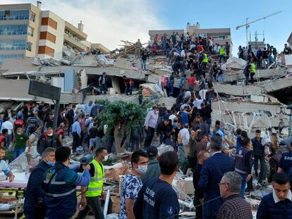 Pessoas tentam resgatar sobreviventes após um terremoto na cidade turca de Izmir, nesta sexta-feira. No vídeo, os efeitos do abalo. 