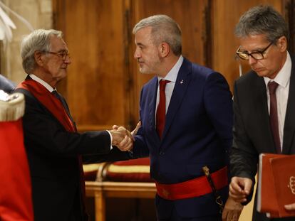 Jaume Collboni, con la vara y el fajín tras hacerse con la alcaldía de Barcelona saluda a Xavier Trias, en el pleno del Ayuntamiento de Barcelona, este sábado.