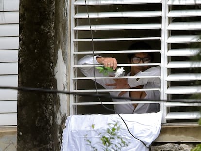 El disidente cubano Yunior García asoma el puño por la ventana de su departamento en La Habana, el 14 de noviembre de 2021.