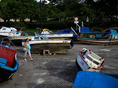 Una mujer camina entre los botes asegurados a la tierra por el paso de la tormenta tropical en La Habana, Cuba, el 5 de julio. En video, las provincias cubanas más expuestas se preparan para la llegada de Elsa.