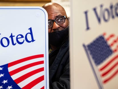 Un hombre llena su papeleta de votación en el centro de votaciones del condado de Cowlitz en Kelso, Washington. En vídeo, las reacciones al resultado de las elecciones.