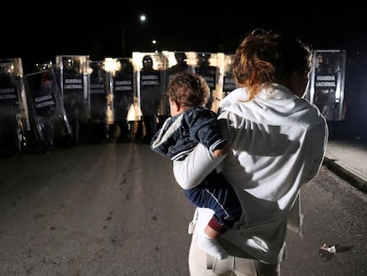 Una mujer con un bebé en brazos en un operativo de dispersión de una caravana de migrantes y solicitantes de asilo, en Huixtla, Chiapas. En video, las declaraciones del presidente de México.