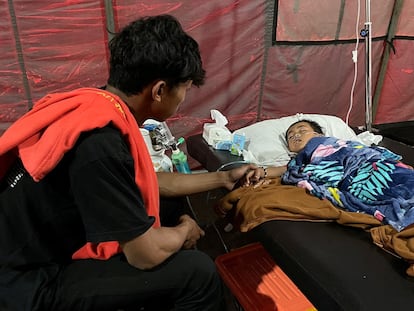 Salman Alfarisi, junto a su hermano Azka, de 6 años, que sobrevivió después de estar atrapado en las ruinas durante dos días después del terremoto del lunes, en una tienda de campaña de emergencia fuera del hospital en Cianjur, Indonesia,  23 de noviembre de 2022. 