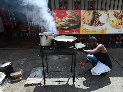 Un hombre cocina con madera en Cali, Colombia.