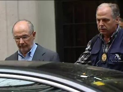 Rodrigo Rato a la salida de su casa y escoltado por la policía.