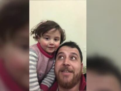El sirio Abdalla, junto a su hija Salwa, mientras juega con ella para que las bombas no le afecten.