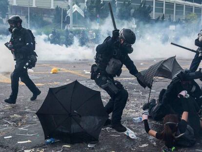Policiais reprimem manifestantes em Hong Kong, nesta terça-feira. ISAAC LAWRENCE. No vídeo, manifestante atingido pela polícia.