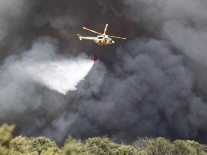 Los helicópteros trabajan entre la humareda.